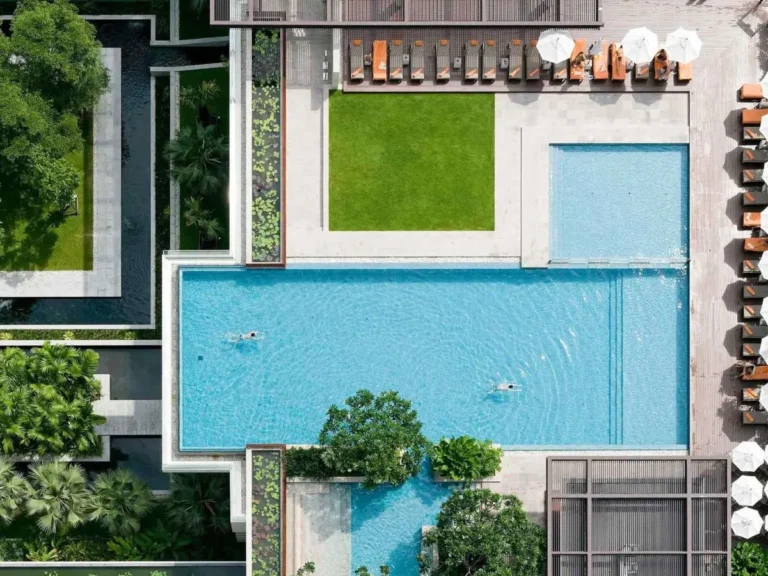 Modern Outdoor Pool Area with Lounge Chairs and Greenery in Ratchathewi Bangkok