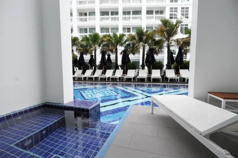 Modern Outdoor Pool Area with Lounge Chairs and Palm Trees at Patong Beach