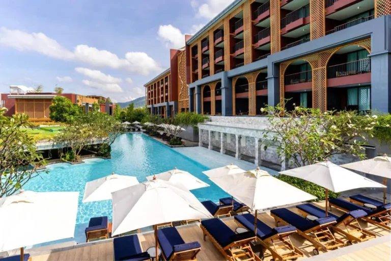 Modern Outdoor Pool Area with Lounge Chairs and Scenic Mountain View at Karon Beach