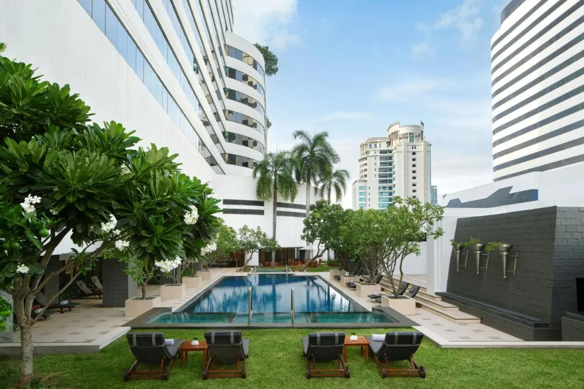 Modern Outdoor Pool Area with Lounge Chairs and Tropical Landscaping in Khlong Toei Bangkok