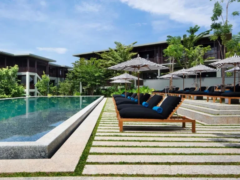Modern Outdoor Pool Area with Lounge Chairs and Umbrellas at Nai Thon Beach