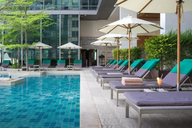 Modern Outdoor Pool Area with Lounge Chairs and Umbrellas in Pathumwan Bangkok
