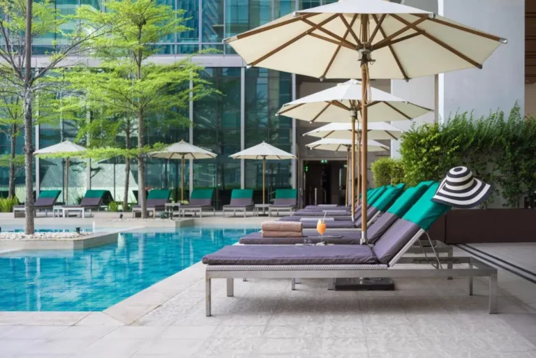Modern Outdoor Pool Area with Lounge Chairs and Umbrellas in Pathumwan Bangkok