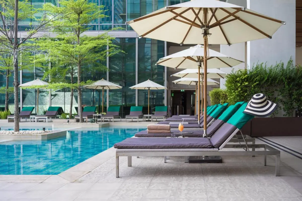 Modern Outdoor Pool Area with Lounge Chairs and Umbrellas in Pathumwan Bangkok