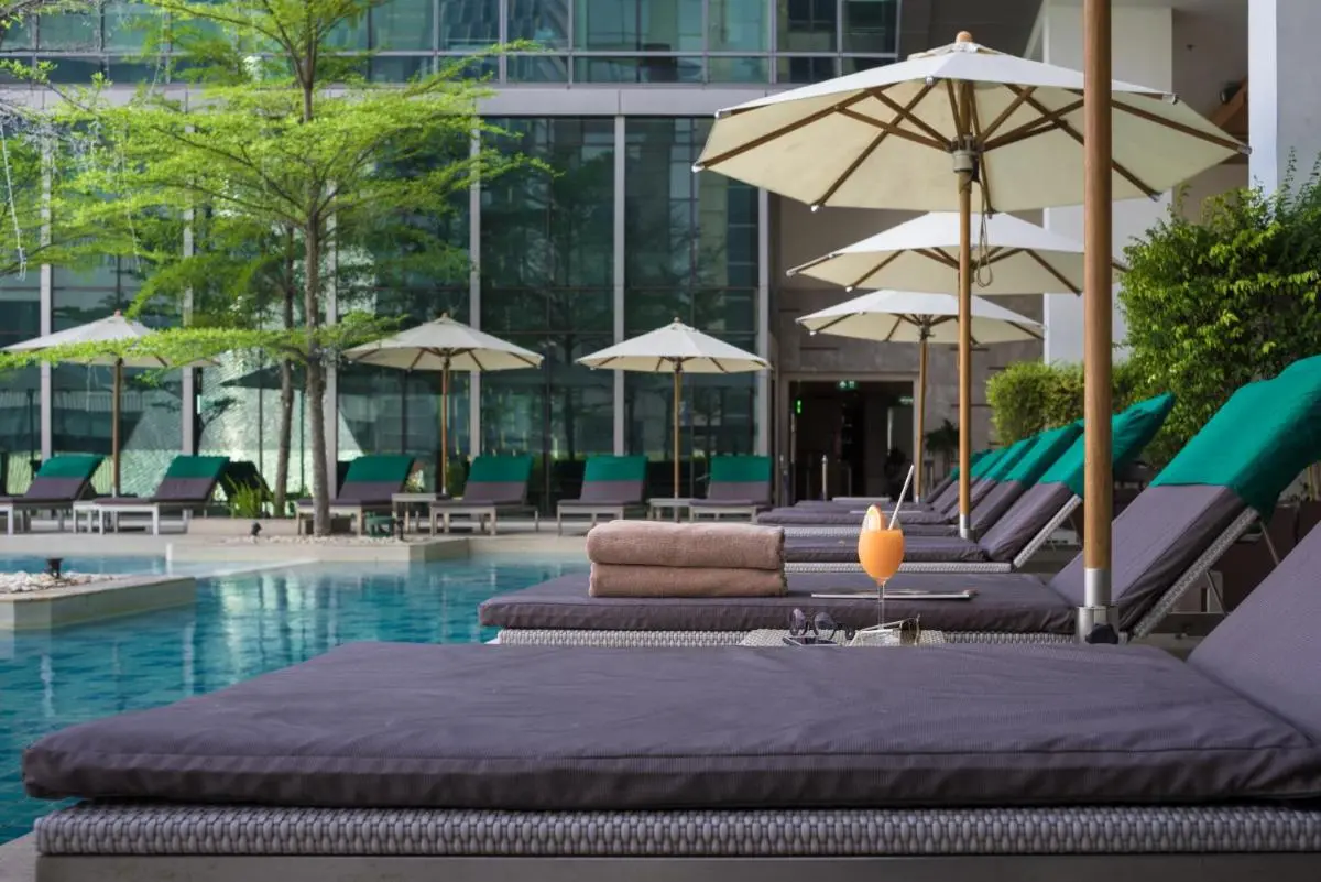 Modern Outdoor Pool Area with Lounge Chairs and Umbrellas in Pathumwan Bangkok