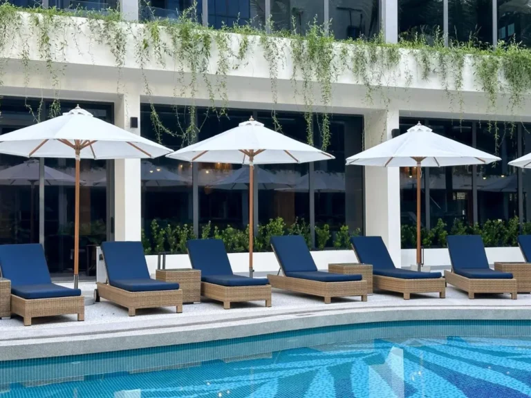 Modern Outdoor Pool Area with Lounge Chairs and White Umbrellas at Bang Tao Beach