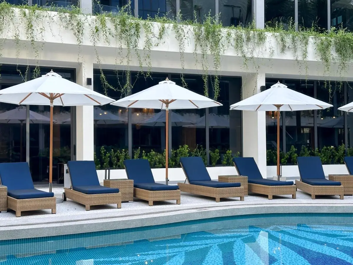 Modern Outdoor Pool Area with Lounge Chairs and White Umbrellas at Bang Tao Beach