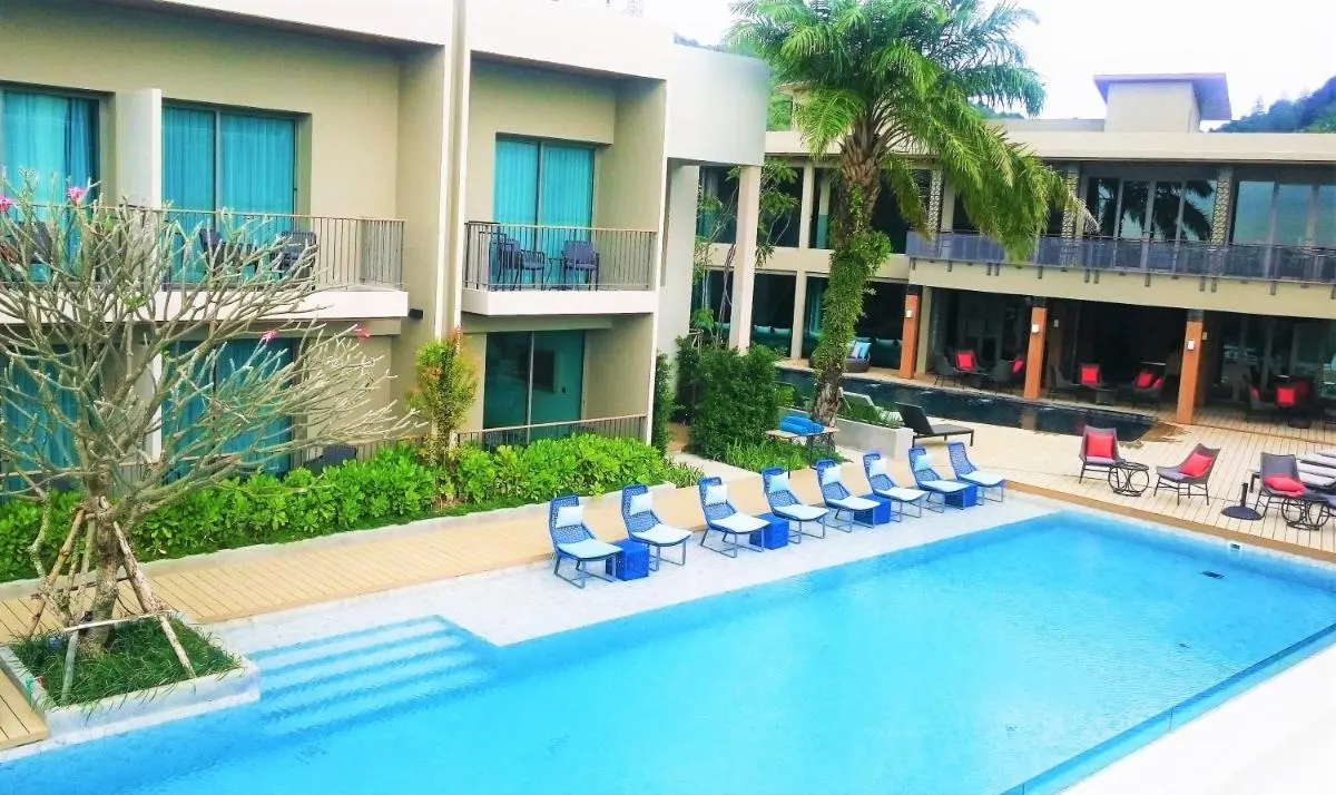 Modern Outdoor Pool Area with Lounge Seating and Natural Surroundings at Patong Beach