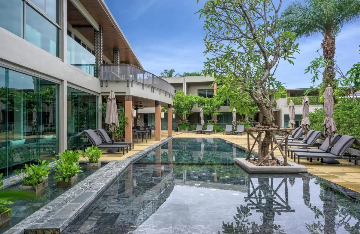 Modern Outdoor Pool Area with Lounge Seating and Natural Surroundings at Patong Beach