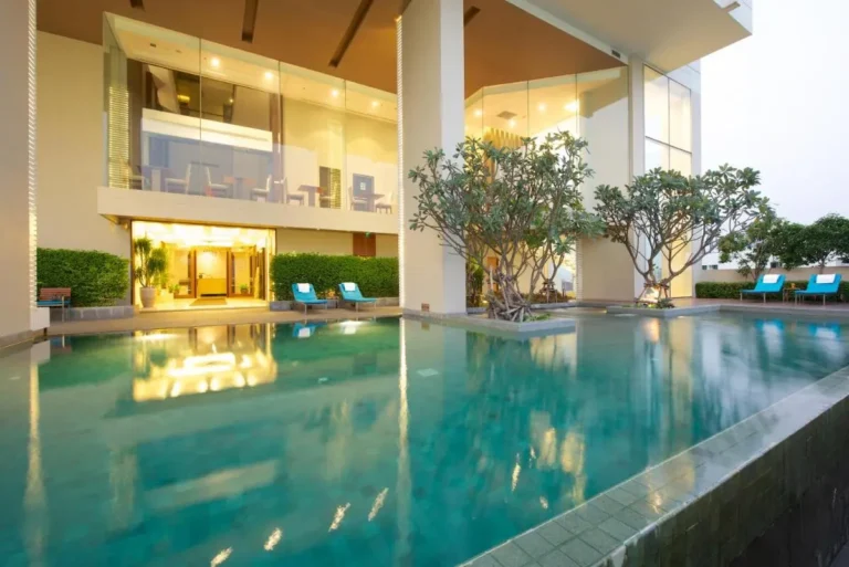 Modern Outdoor Pool Area with Lounge Seating and Planted Islands in Wattana Bangkok
