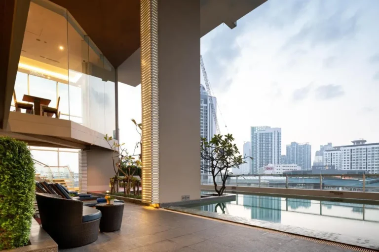 Modern Outdoor Pool Area with Lounge Seating and Urban Views in Wattana Bangkok
