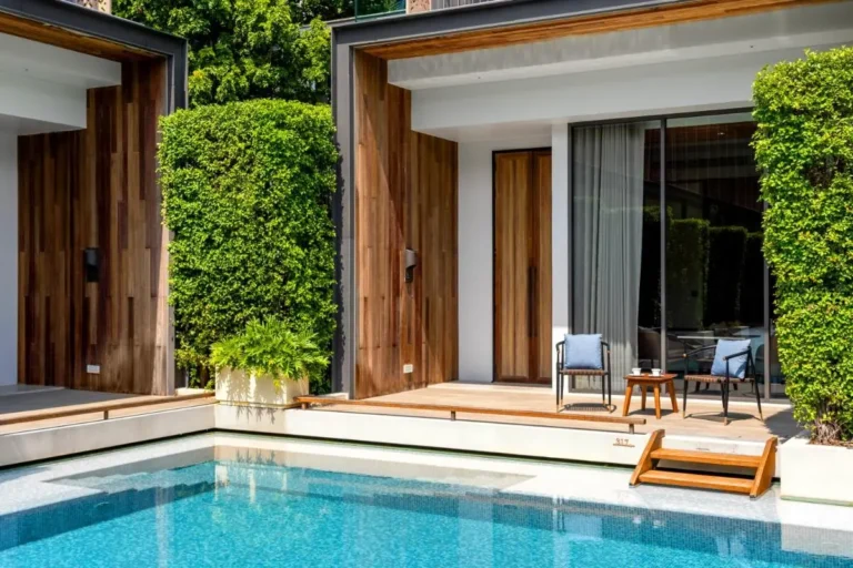 Modern Outdoor Pool Area with Wooden Deck and Privacy Hedges in Sathorn Bangkok