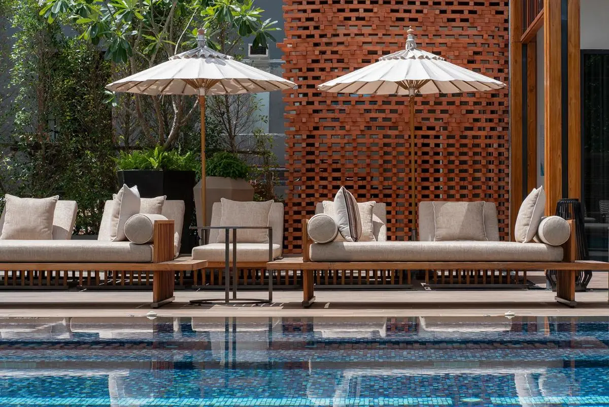 Modern Outdoor Pool Area with Wooden Lounge Beds and Parasol Shade in Chang Khlan Chiang Mai