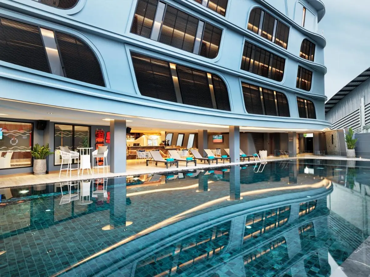 Modern Outdoor Swimming Pool Area with Lounge Seating and Covered Deck in Phuket Town