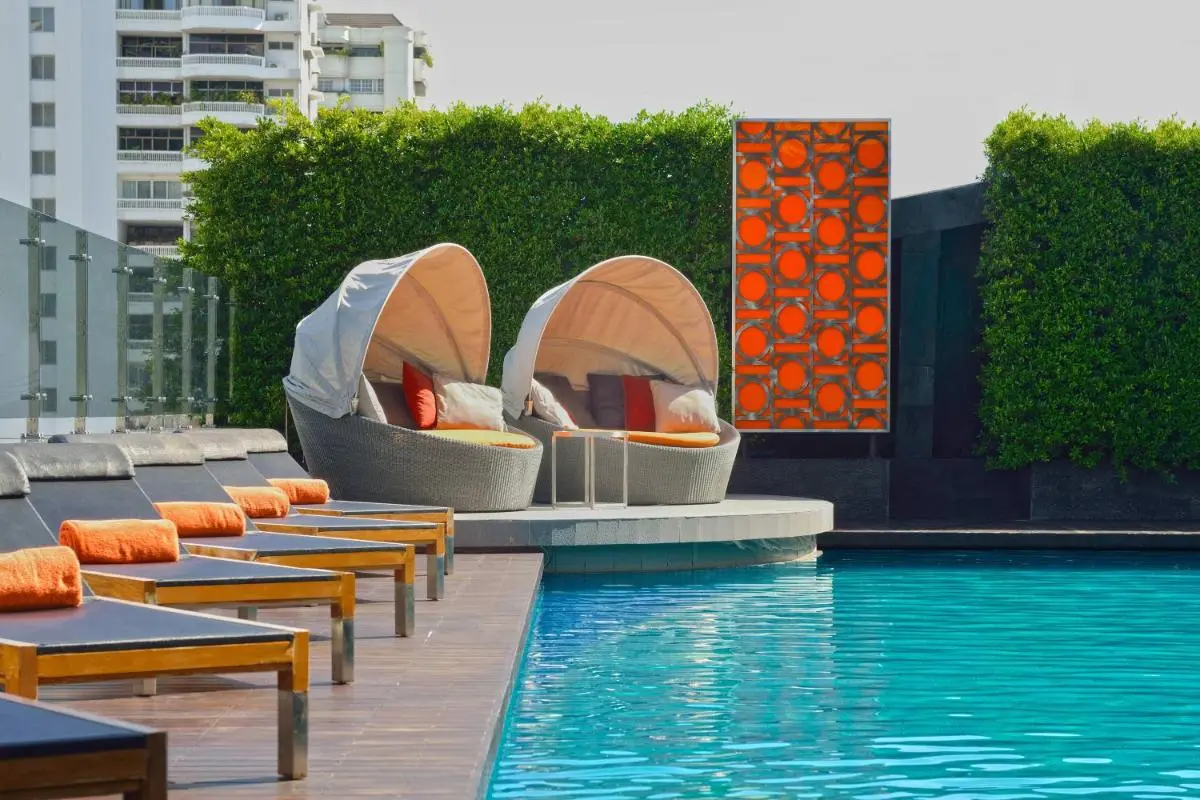 Modern Outdoor Swimming Pool Area with Lounge Seating and Privacy Hedge in Wattana Bangkok