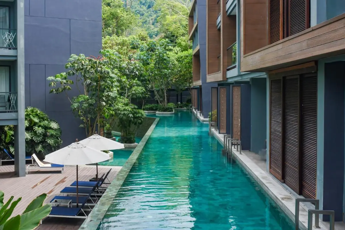 Modern Outdoor Swimming Pool with Lounge Area and Natural Greenery at Patong Beach