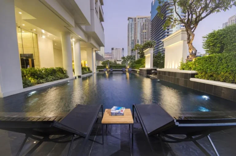 Modern Outdoor Swimming Pool with Lounge Area and Urban Views in Pathumwan Bangkok