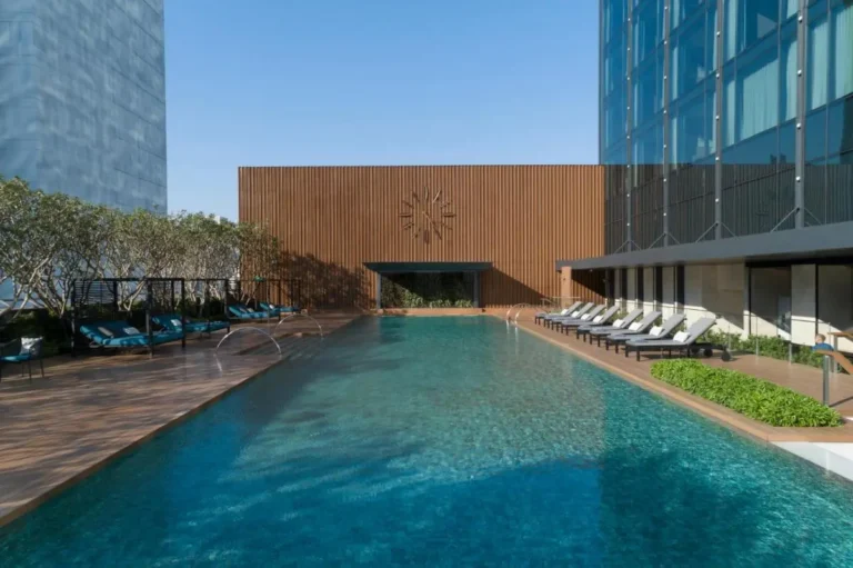 Modern Outdoor Swimming Pool with Lounge Chairs and Water Fountains in Wattana Bangkok