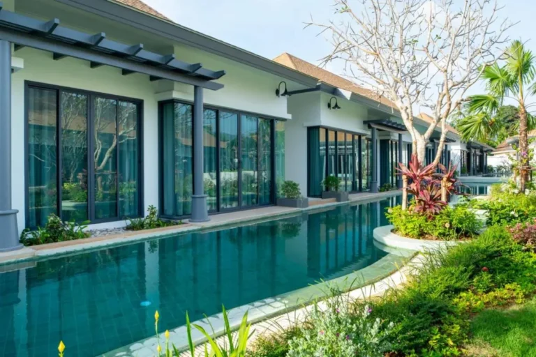 Modern Residential Poolside Area with Glass Facades and Landscaped Garden in Chalong
