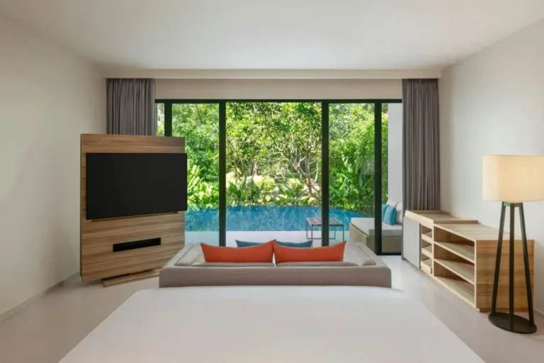 Modern Room with Glass Doors Opening to Private Pool and Lush Greenery at Mai Khao Beach