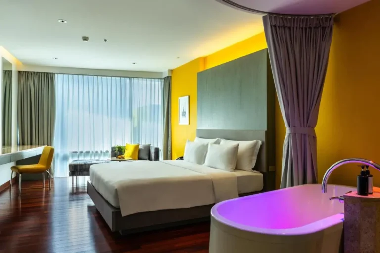 Modern Room with Illuminated Freestanding Bathtub and Large Window in Pathumwan