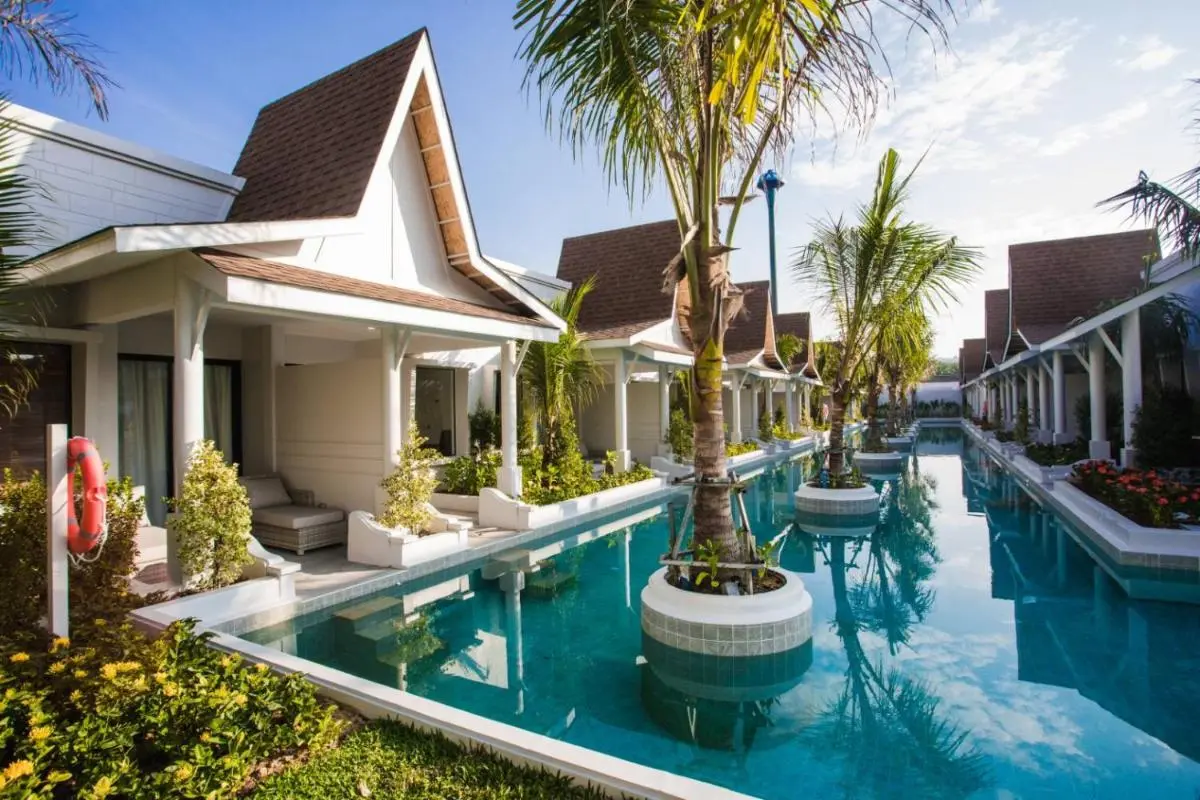 Narrow Rectangular Swimming Pool with Palm Planters Between Single-Story Buildings in Thalang