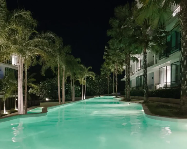 Night View of Narrow Illuminated Swimming Pool Surrounded by Palm Trees at Rawai Beach