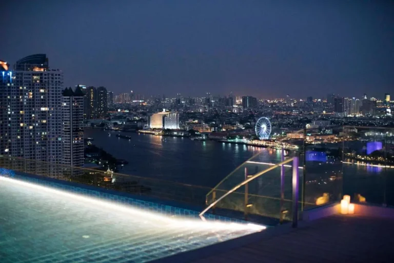 Nighttime Infinity Pool and Cityscape Views Over Thonburi Waterfront Area