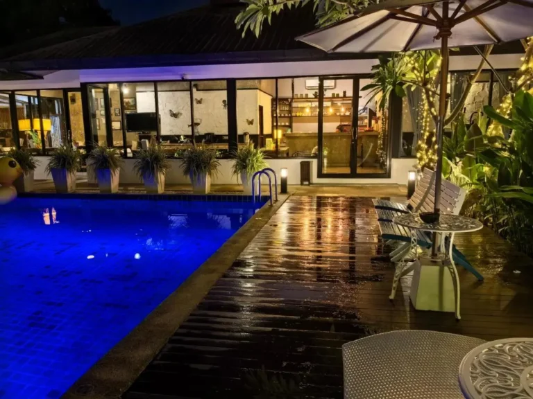 Nighttime Outdoor Pool and Relaxation Area with Seating in Wat Ket Chiang Mai