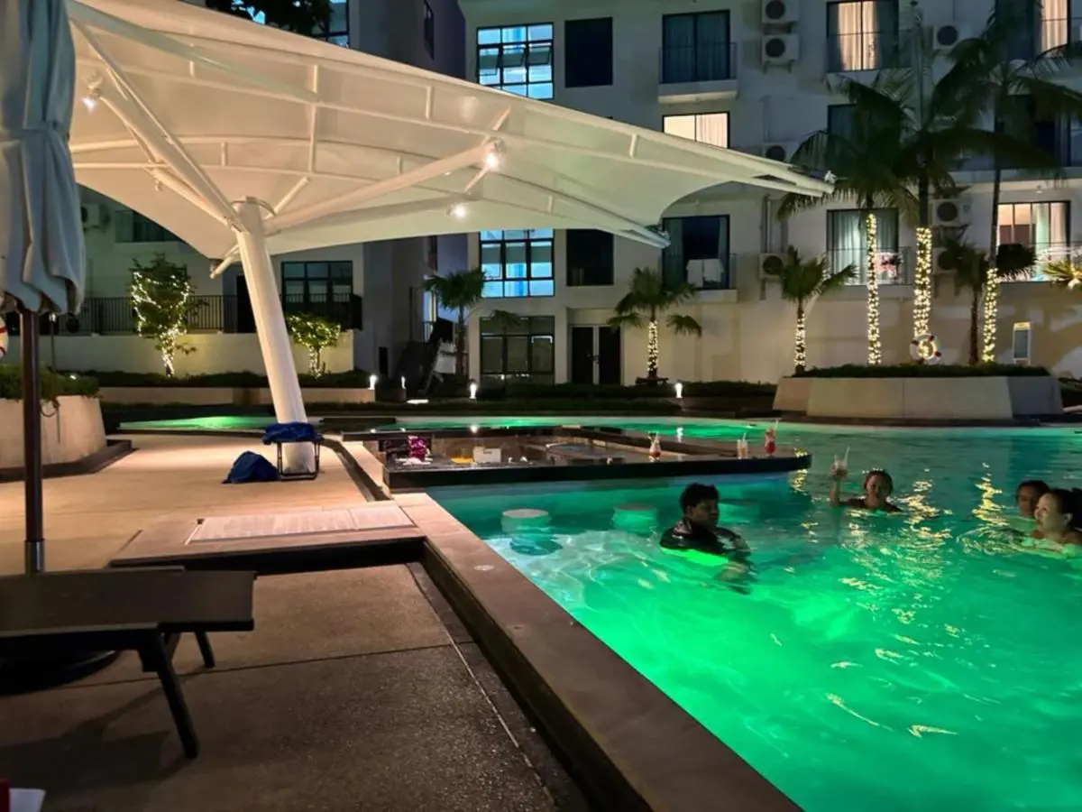 Nighttime Outdoor Pool Area with Underwater Lighting and Built-In Bar Seating at Rawai Beach