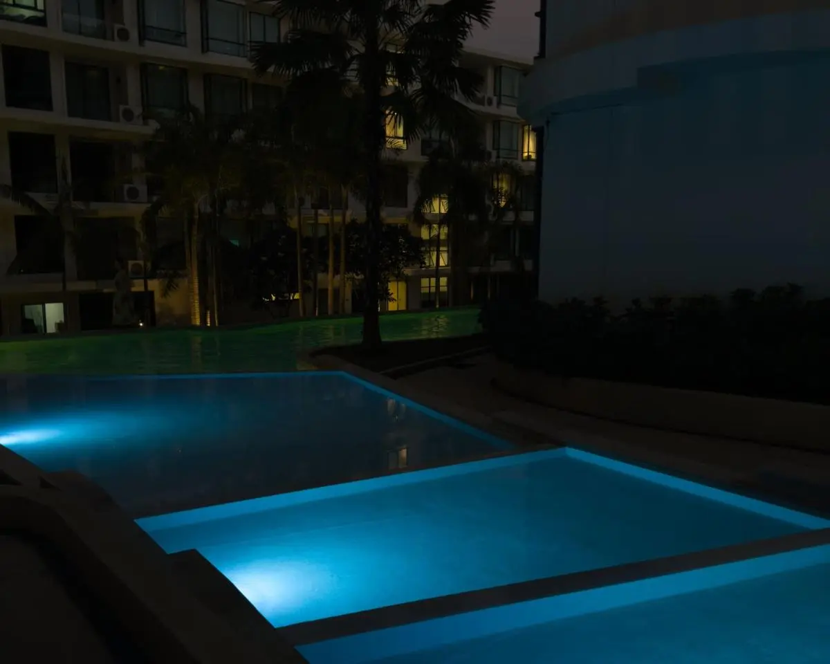 Nighttime View of Illuminated Outdoor Pools with Palm Trees at Rawai Beach