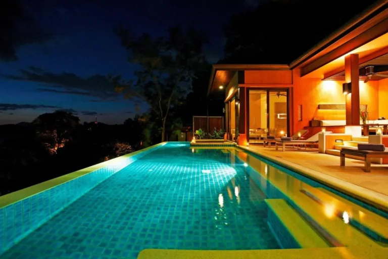 Nighttime View of Illuminated Outdoor Swimming Pool and Lounge Area at Panwa Beach