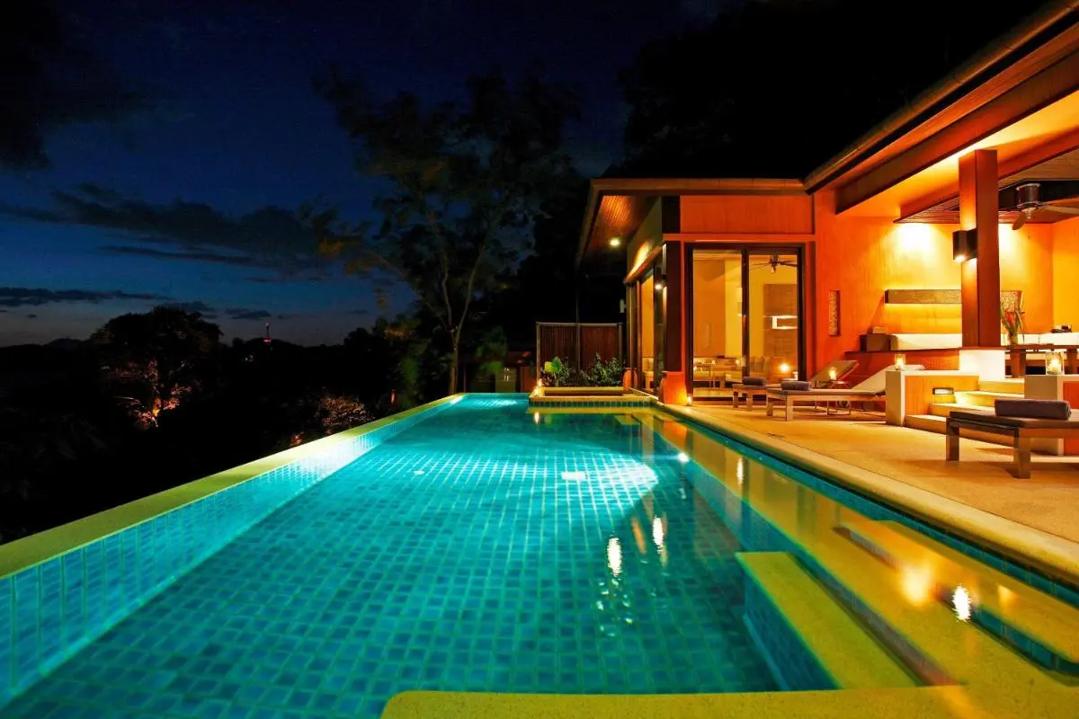 Nighttime View of Illuminated Outdoor Swimming Pool and Lounge Area at Panwa Beach