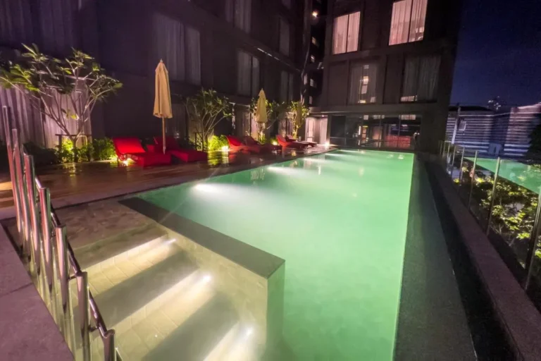 Nighttime View of Illuminated Outdoor Swimming Pool and Lounge Area in Khlong Toei Bangkok