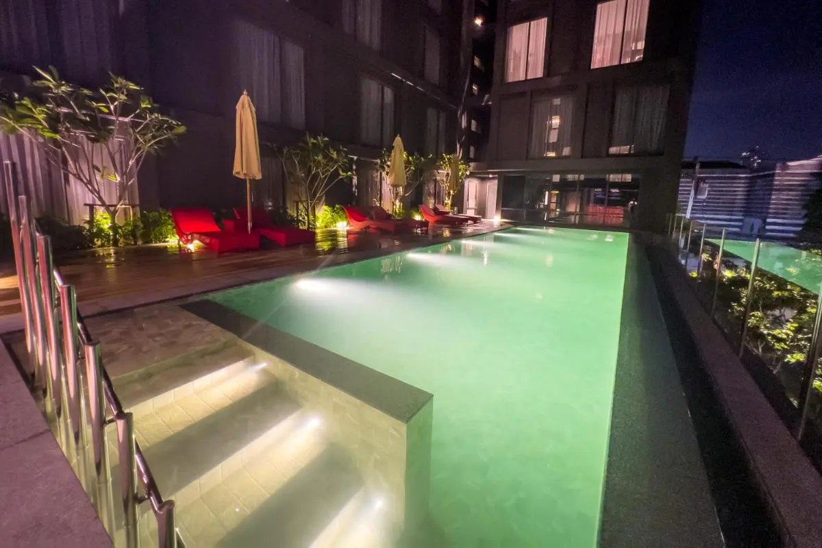 Oakwood Studios Sukhumvit Bangkok Nighttime View of Illuminated Outdoor Swimming Pool and Lounge Area in Khlong Toei Bangkok