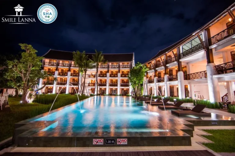 Nighttime View of Illuminated Outdoor Swimming Pool with Lounge Area in Hai Ya Chiang Mai
