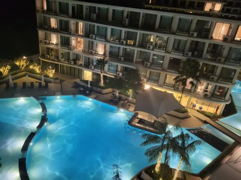 Nighttime View of Illuminated Outdoor Swimming Pool with Lounge Seating at Rawai Beach