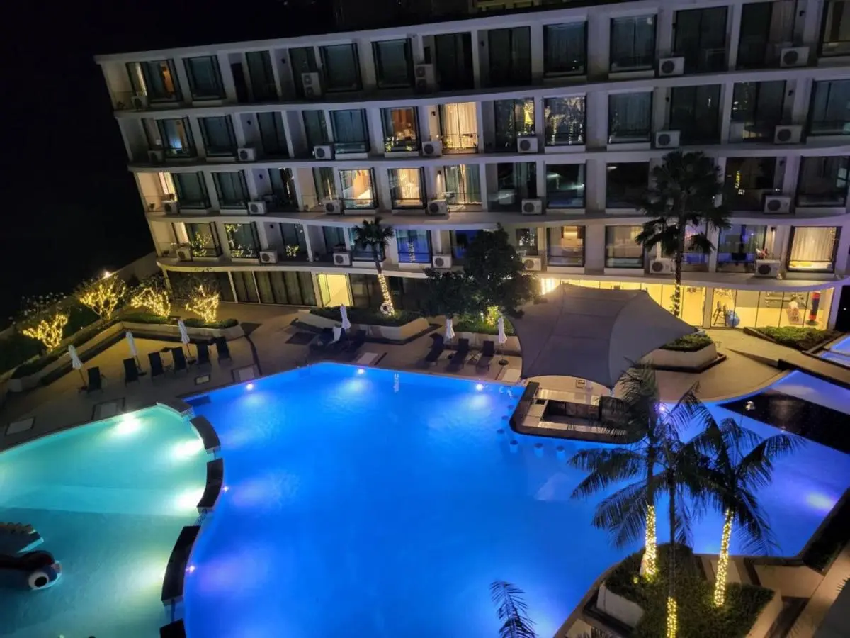 Nighttime View of Modern Outdoor Pool Area with Illuminated Jacuzzi and Seating at Rawai Beach