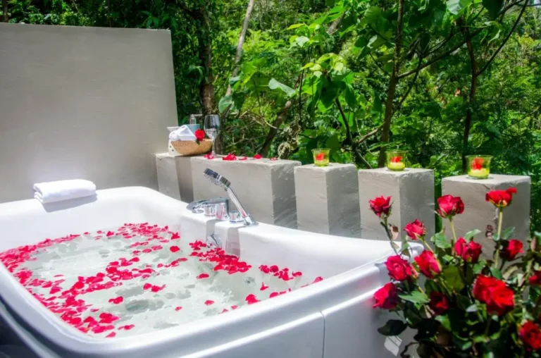 Outdoor Bathtub with Rose Petals and Candlelit Pedestals in Natural Setting at Patong Beach