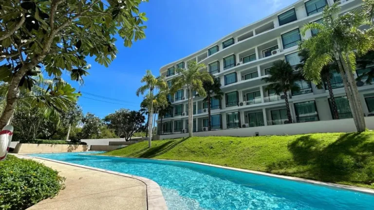 Outdoor Curved Swimming Pool with Palm Trees and Residential Balconies at Rawai Beach