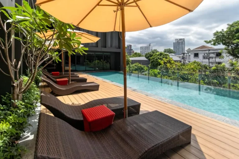 Outdoor Elevated Pool Area with Lounge Chairs and Urban Views in Khlong Toei Bangkok
