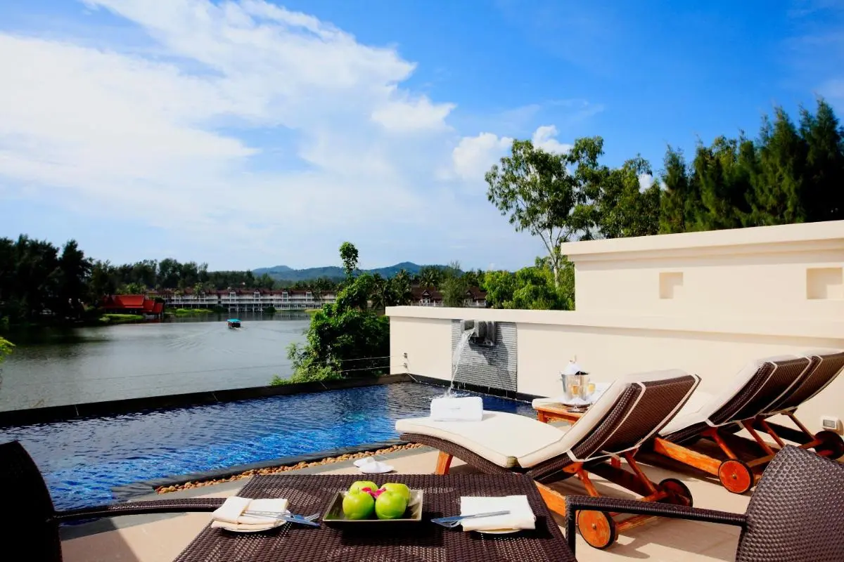 Outdoor Infinity Pool and Relaxation Area Overlooking Scenic Water and Hills at Bang Tao Beach