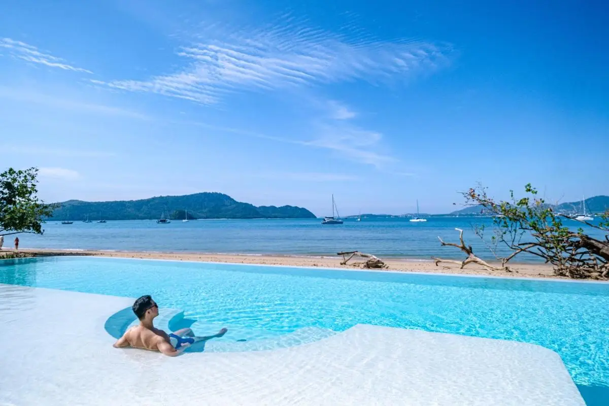 Outdoor Infinity Pool Overlooking Panwa Beach with Clear Blue Water and Sailboats