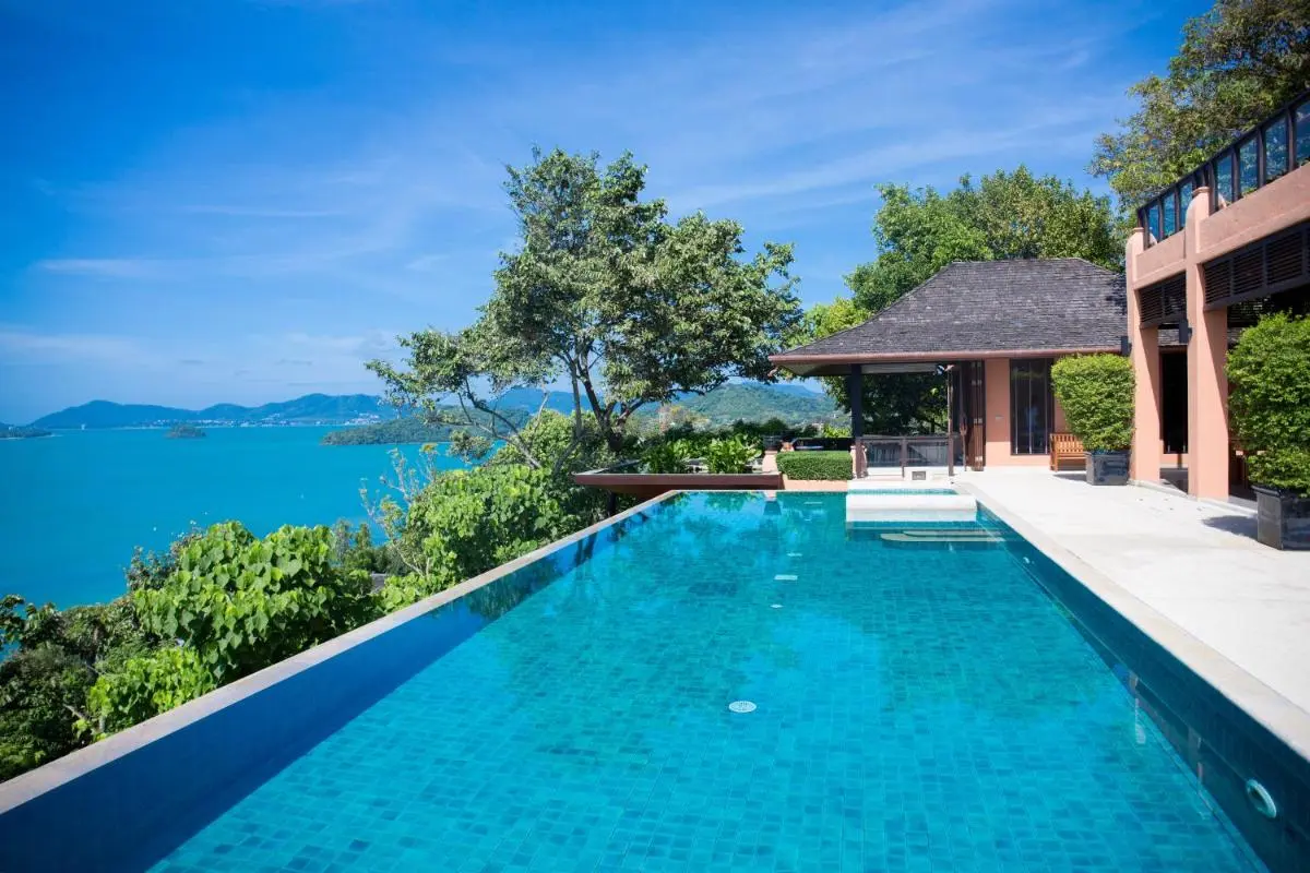 Outdoor Infinity Pool Overlooking Turquoise Waters at Panwa Beach with Relaxation Area
