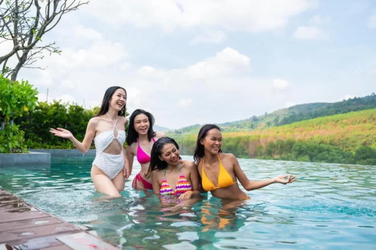 Outdoor Infinity Pool with Four Women and Scenic Natural Landscape in Phuket Town Outdoor Infinity Pool with Four Women and Scenic Natural Landscape in Phuket Town
