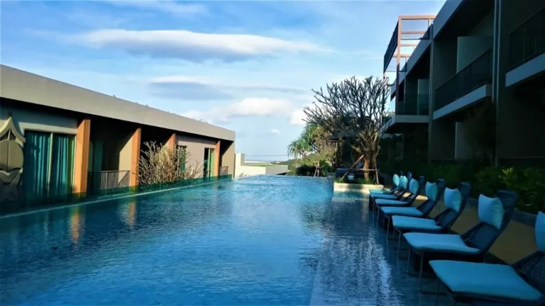 Outdoor Infinity Pool with Lounge Chairs and Natural Landscape at Patong Beach