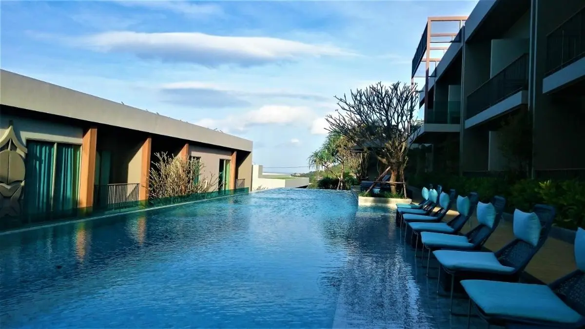 Outdoor Infinity Pool with Lounge Chairs and Natural Landscape at Patong Beach