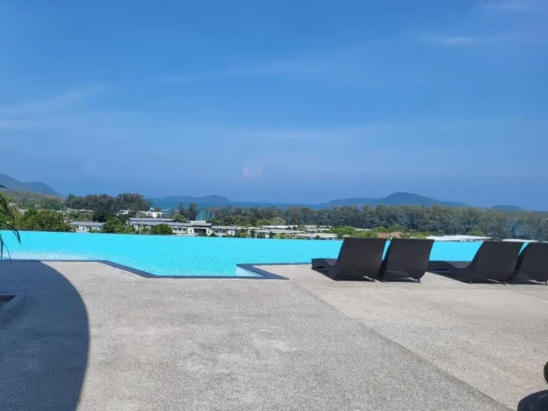 Outdoor Infinity Pool with Modern Lounge Chairs Overlooking Coastal Views at Rawai Beach