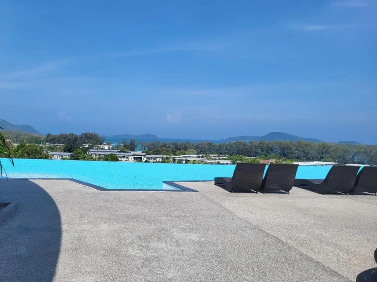 Outdoor Infinity Pool with Modern Lounge Chairs Overlooking Coastal Views at Rawai Beach