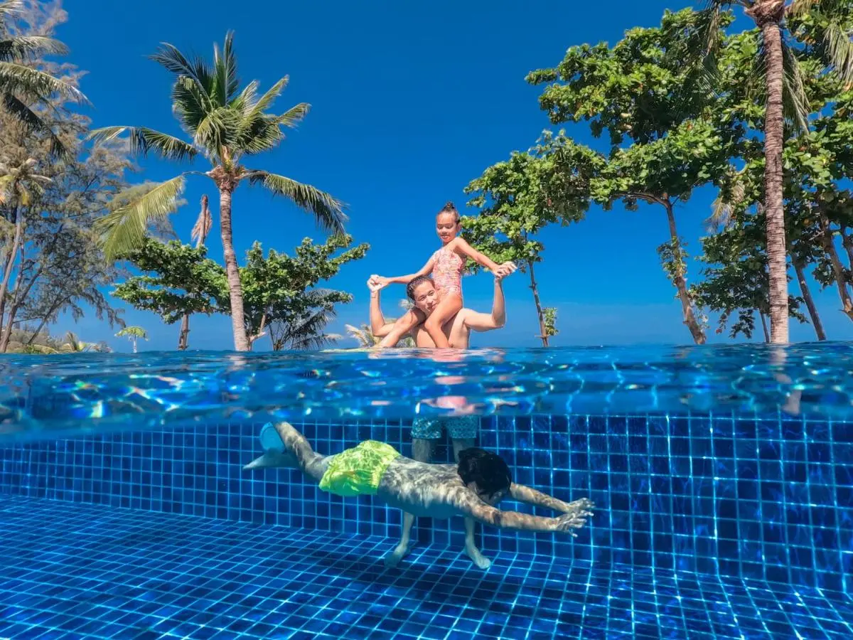 Outdoor Infinity Pool with Tropical Surroundings and Family Enjoying Water at Kamala Beach